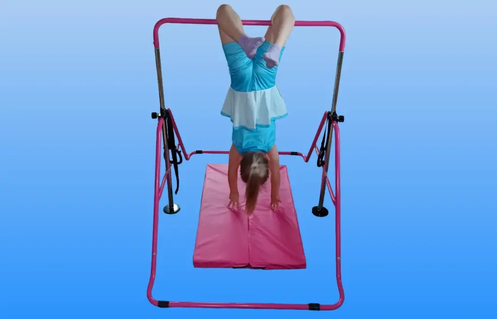 Mädchen macht einen Handstand an der pinken Gymnastikstange für Kinder zuhause