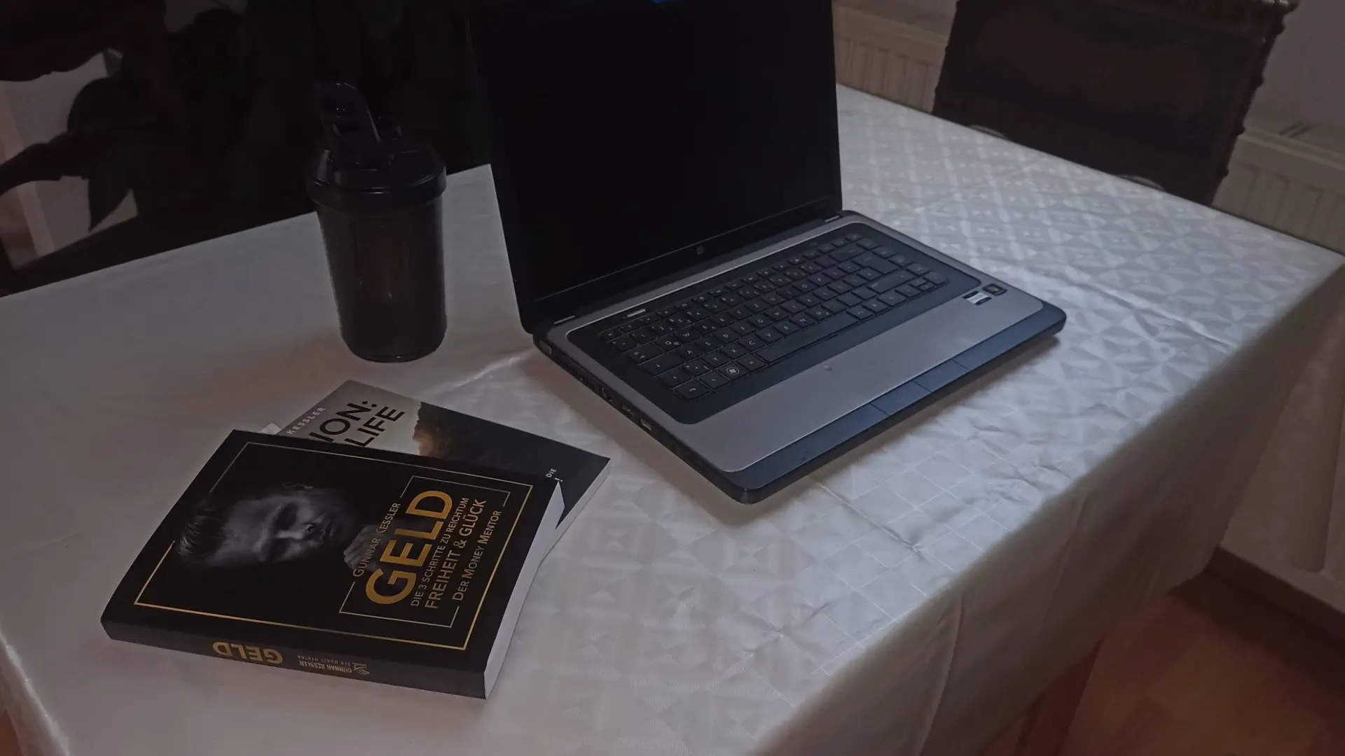 Laptop, Protein-Shaker und Mindset-Bücher auf einem Tisch für das Toptipps24 Home-Office