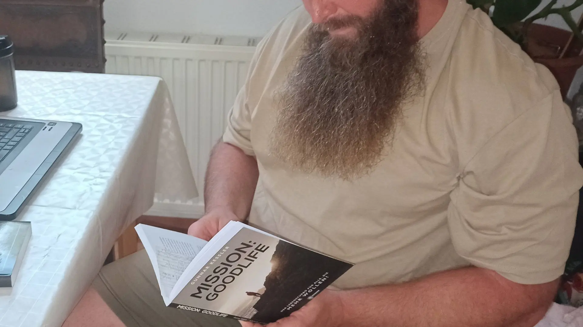 David von Toptipps24 liest fokussiert das Buch Mission Good Life von Gunnar Kessler am Tisch